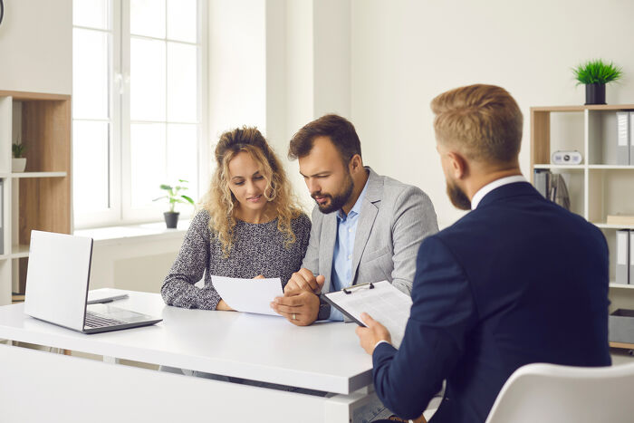 Tenants sitting at office desk and reading terms and conditions of contract document